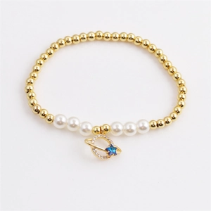 Elegant gold bead and pearl bracelet featuring a crystal ring and blue star charm