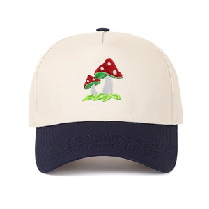 Close-up of mushroom embroidery on a two-tone beige and navy cotton baseball cap