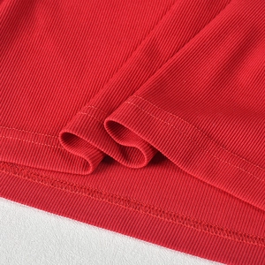 Detailed macro view of red ribbed fabric showing high-quality double stitching and texture