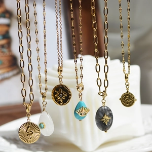 Detail of vintage gold stainless steel necklaces with turquoise and stone pendants