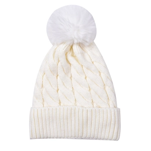 Detailed view of the thick cable knit pattern and soft faux fur pom-pom on the ivory beanie
