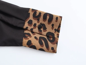 Detail der Hemdmanschette mit Leopardenmuster-Patchwork und einem schwarzen Knopf