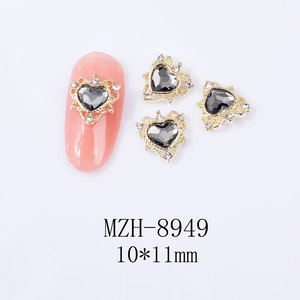 Detail view of heart-shaped alloy nail charms with black gems and gold hollow frame
