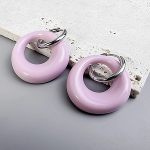 Close-up of lavender purple oval drop earrings on white stone with 18K gold buckle