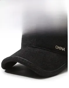 Detail of gray wool felt cap featuring metal logo and reinforced stitching on the brim