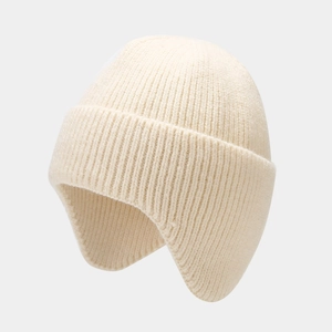 Detail of solid color knitted earflap hat showing the chunky ribbed weave texture
