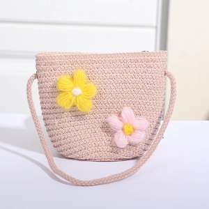 Detailaufnahme der rosa geflochtenen Mini-Strohtasche mit bunten Plüschblumen-Akzenten