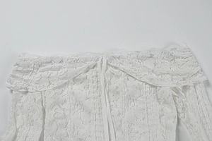 Detail of white eyelash lace neckline with intricate floral pattern on summer dress
