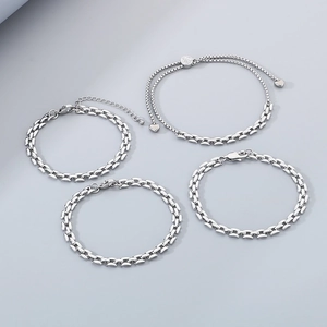 Close-up of four silver stainless steel bracelets including heart charm and chain link styles