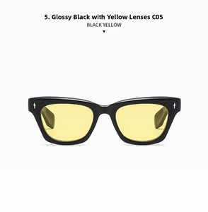 Detail of glossy black sunglass frames with yellow lenses and silver diamond rivet accents