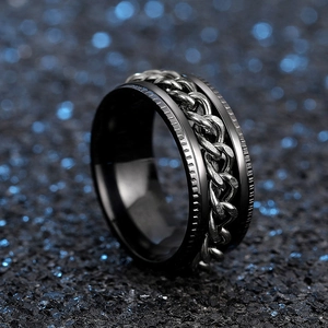 Macro detail of a rotating black stainless steel chain ring with punk industrial texture