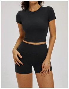 Close-up of black tight-fit short sleeve yoga crop top and high-waisted gym shorts set