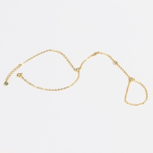 Detailed view of 18k gold plated finger bracelet chain with inlaid diamonds and heart charm