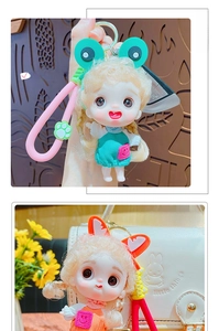 Detailed close-up of a cute cartoon doll keychain with green frog glasses and pink strap