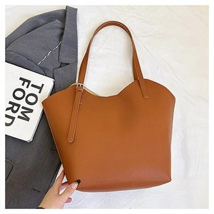 Dettaglio della borsa tote marrone vintage con bordi ondulati e pelle grana litchi