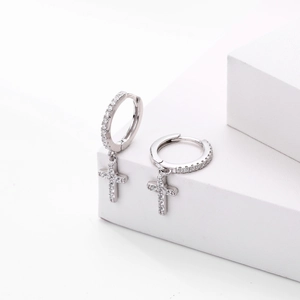 Macro detail of S925 sterling silver cross earrings with sparkling cubic zirconia stones