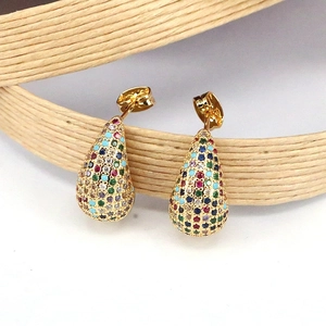 Détail macro de boucles d'oreilles goutte dorées avec oxydes de zirconium colorés