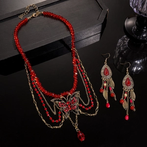 Détail du collier de perles rouges avec pendentif papillon et boucles d'oreilles luxe