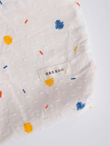 White textured floral makeup bag with colorful polka dots and H&R BAG logo tag