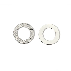 Macro detail of polished silver oval stainless steel rings with embossed texture patterns