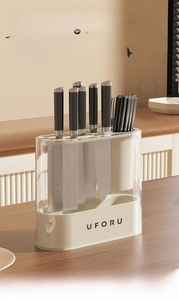 Close-up of modern acrylic kitchen knife block with utensil holder on wooden table