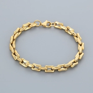 Detail of a minimalist gold link chain bracelet in high-polished stainless steel finish