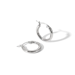 Détail de grandes boucles d'oreilles créoles en acier argenté avec finition brillante