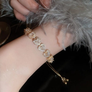Detail of adjustable gold heart bracelet with micro-paved zircons and drawstring closure