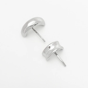 Macro detail of glossy silver crescent moon shaped metal earrings with stud backings