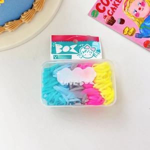 Dettaglio di elastici per capelli colorati in scatola trasparente con elastici blu e rosa