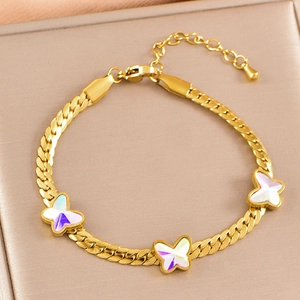 Golden bracelet with iridescent butterfly charms on a champagne textured jewelry box