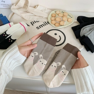 Close-up of grey mid-calf socks with cute rabbit patterns made of combed cotton