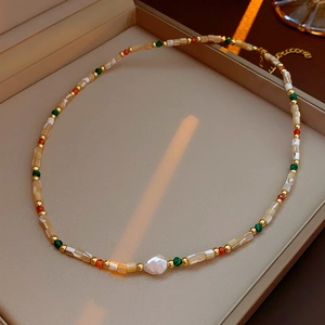 Macro shot of baroque freshwater pearl necklace with colorful beads in a jewelry box