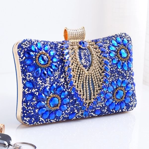 Detailed close-up of blue rhinestone evening clutch with gold floral filigree