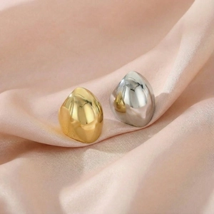 Polished gold and silver stainless steel irregular rings on elegant pink silk fabric
