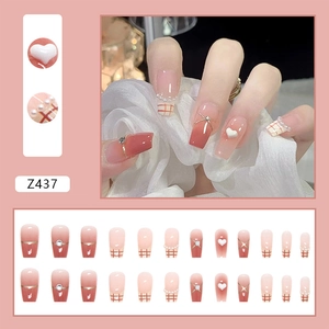Detail of French blush nails with red plaid patterns, pearls, and rhinestone accents