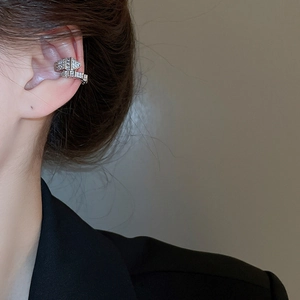 Close-up of silver snake-shaped C-clamp ear cuff with sparkling zircon inlay for women