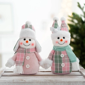 Detail shot of two plush Christmas snowmen in pink and mint green with cozy scarves