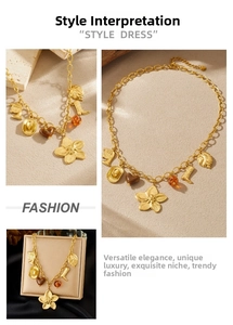 Vintage gold necklace with charms like flowers, hearts, and boots on a luxury display