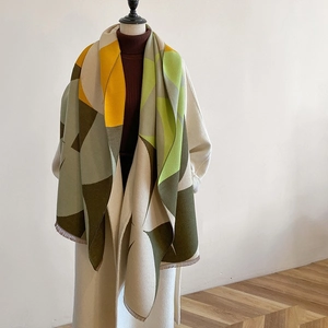 Close-up of thick geometric color-block scarf with warm yellow and green knit texture