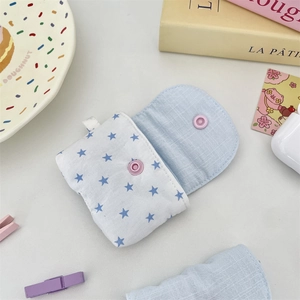 Close-up of small blue fabric earphone pouch with star patterns and pink button snap