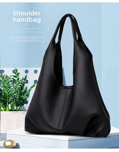 Detail of minimalist black large-capacity tote bag in soft lychee textured leather