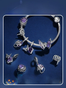 Detail of Halloween 925 silver beaded bracelet with purple zircons and skull charms