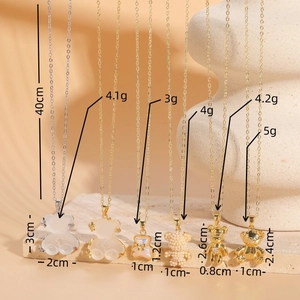 Divers pendentifs d'ours et de perles sur des colliers plaqués or 14K sous lumière douce