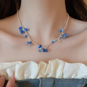 Gros plan du collier de perles avec pendentif étoile et fleur sur le cou d'une femme
