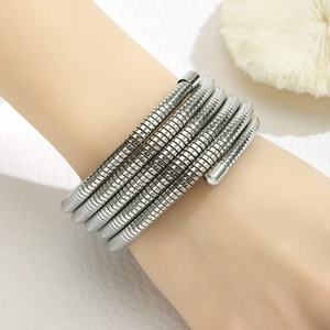 Macro detail of multi-layer stainless steel spring coil bracelet with silver metallic shine