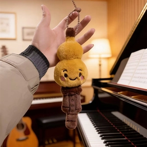 Plush musical instrument doll keychain with cute cartoon face held against a warm piano room