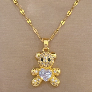 Close-up of gold teddy bear pendant with micro-pave crystals and heart-shaped center stone