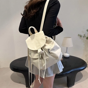 Rear view of cream white nylon backpack with drawstring flap closure and adjustable straps