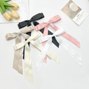 Collection of satin bow hair clips in black, pink, beige, and white colors